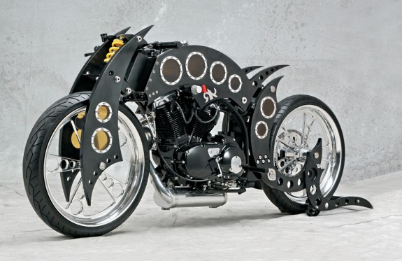 Еще один безумный агрегат от Рафика Каисси из RK Concepts. Называется RK Racer и представляет собой… черт знает что. 1,2-литровый мотор и коробка передач – от Buell. Колеса – 23-дюймовые CMH. Шины – «стодвадцатки» Vee Rubber. Переднего тормоза нет, задний – трансмиссионный, с суппортом Brembo. Резервуарами для топлива и масла служат цилиндры со стеклянными «окнами», соединяющие боковины рамы. В общем с рамой футуристическом стиле решены также вилка-гердер и подставка, в сложенном виде превращающаяся в сиденье.